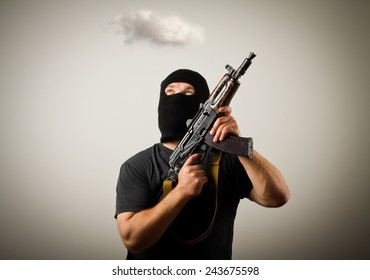 Man in mask with gun and white cloud. Imagination concept.