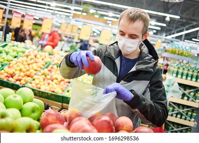 Mann in Maske und Schutzhandschuhen, der Lebensmittel im Laden bei der Epidemie des Koronavirus kauft
