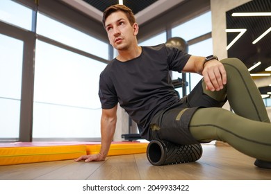 The man is massaging his leg muscles with the foam roller - Powered by Shutterstock