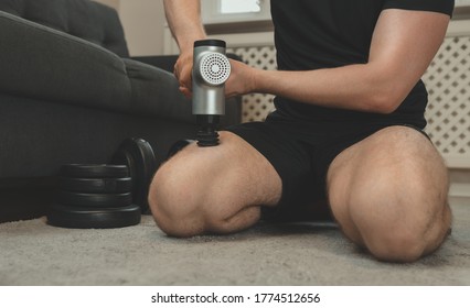 Man Massaging Leg With Massage Percussion Device.