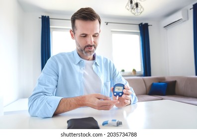 Man measures his blood sugar. Glucometer, blood sample test, diabetes concept.
