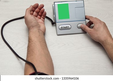 A man measures his pressure with a pripore. - Shutterstock ID 1335964106
