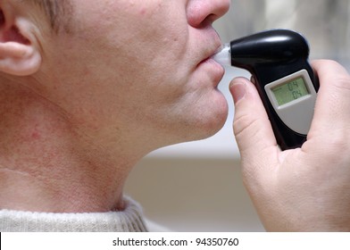 Man Measures The Level Of Blood Alcohol By Breathalyzer