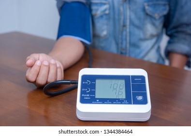 man measuring and checking blood pressure of patient 