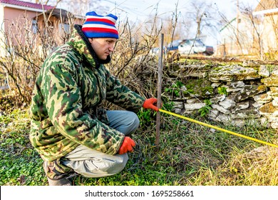 Man With Measuring Tape Working On Vegetable Winter Garden For Post Raised Bed Cold Frame In Ukraine Dacha