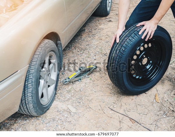 Man mechanic\
changing a wheel broken car