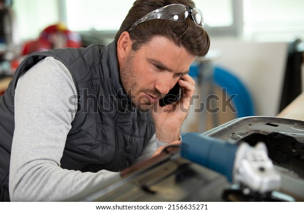 man mechanic on the\
phone
