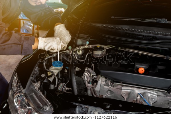 A man mechanic are repair a\
car Use a wrench and a screwdriver. to work.Safe and confident in\
driving. Regular inspection of used cars. It is very well\
done.