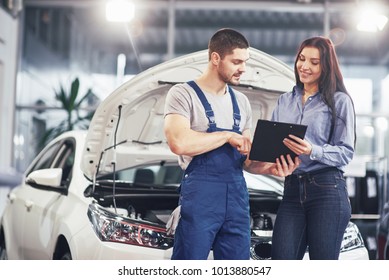 A man mechanic and woman customer discussing repairs done to her vehicle. - Powered by Shutterstock