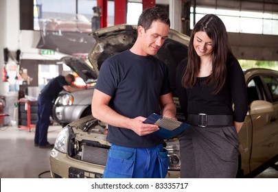 A Man Mechanic And Woman Customer Discussing Repairs Done To Her Vehicle