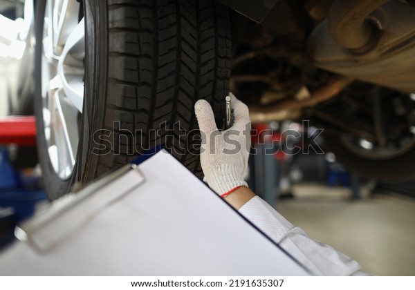 Man\
mechanic working under car at car service\
station