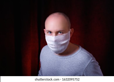 A Man In Medical Gauze Mask Standing On Dark Red Background. Virus Preventive Methods. Protection Of Upper And Lower Respiratory System From  Chinese Coronavirus Concept.