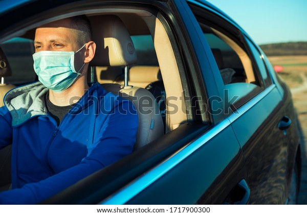Man in the medical mask in car.\
coronavirus, disease, infection, quarantine,\
covid-19