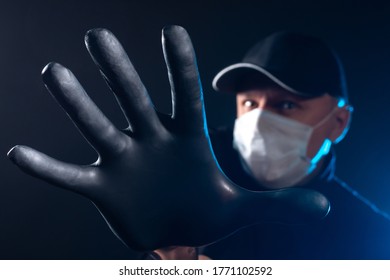 Man in a medical mask holds out his hand. Human is trying to stop with a gesture. Concept - attempt to stop the disease. Prevention of the spread of the disease. Infected man in gloves and a mask.