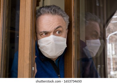 Man With Medical Mask Opens The House Door. Coronavirus Concept. Respiratory Protection. Quarantine At Home.