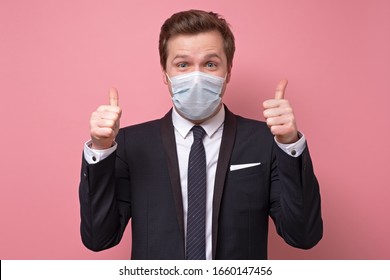 The Man In A Medical Mask Showing Thumb Up Approving Your Choice. Studio Shot