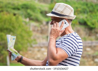 Man In Medical Mask With A World Map In His Hand And In The Other The Mobile Phone, Concept Of Travel In The New Normal