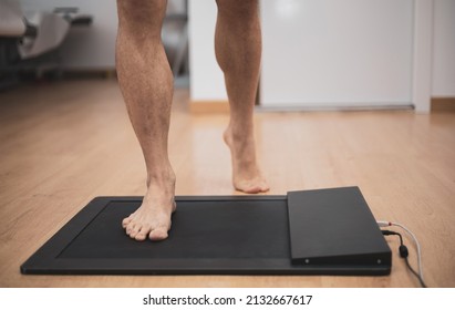 a man in a medical office specialized in posurology with his feet on a platform to analyze the pressure exerted and the biomechanical study of foot drop - Shutterstock ID 2132667617