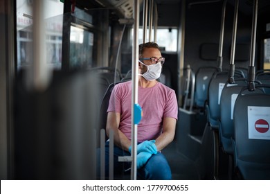 Man with medical protective mask and gloves sitting in an emtpy bus.