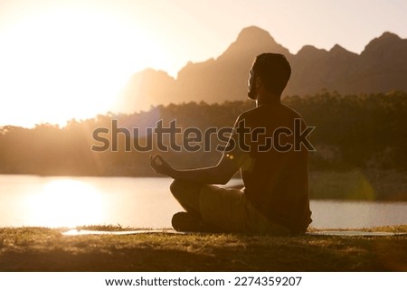 Man Meditating Doing Yoga By Lake And Mountains At Sunset Foto d'archivio © 