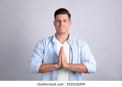 Man meditating on light background. Stress relief exercise