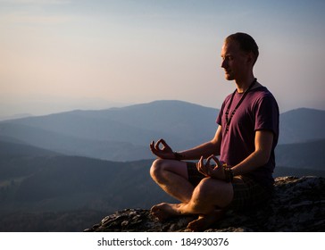 Man Meditating On A Rock