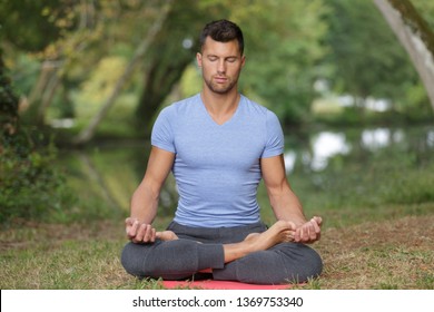 Man Meditating Outside By River