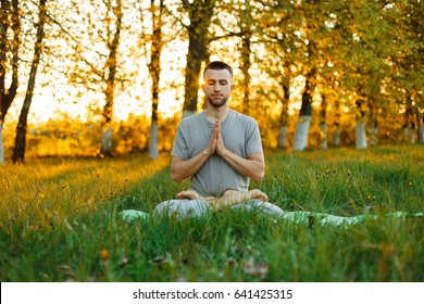 Man meditating in a park at sunset. Healthy lifestyle
