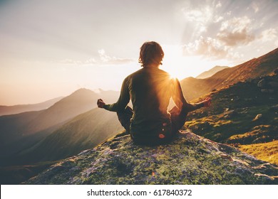 Man meditating yoga at sunset mountains Travel Lifestyle relaxation emotional concept adventure summer vacations outdoor harmony with nature