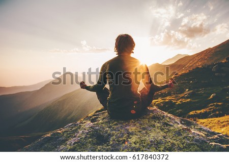 Man meditating yoga at sunset mountains Travel Lifestyle relaxation emotional concept adventure summer vacations outdoor harmony with nature Foto stock © 
