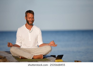 Man, meditation and phone for yoga by ocean with holistic healing, spiritual wellness and zen performance. Happy, mature person and mobile for namaste tutorial, mindfulness peace and fitness outdoor - Powered by Shutterstock