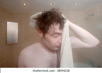 A Man With Messy Hair Dries Himself With A Towel In Front Of The Mirror