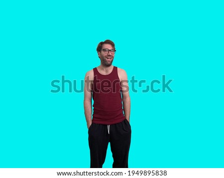 Man with messy hair and glasses shows a slight smile with a blue background