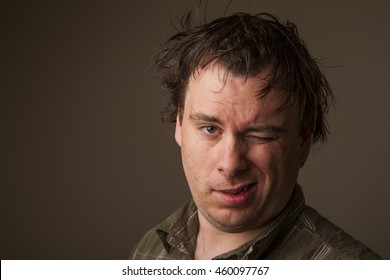 Man with messy hair winks at the camera