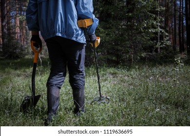 A Man With A Metal Detector In The Woods