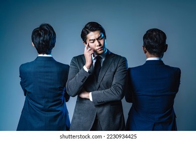 A man in a middle management position who is troubled between his boss and his subordinates. - Shutterstock ID 2230934425