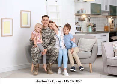 Man In Military Uniform With His Family On Sofa At Home