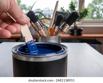 A man mixes blue paint in a jar by hand
 - Powered by Shutterstock