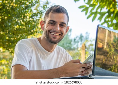 Mann mit Mobiltelefon und Computer-Telearbeit im Freien