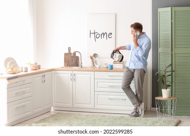 Man with mobile phone pouring hot boiled water from electric kettle into cup at home - Powered by Shutterstock