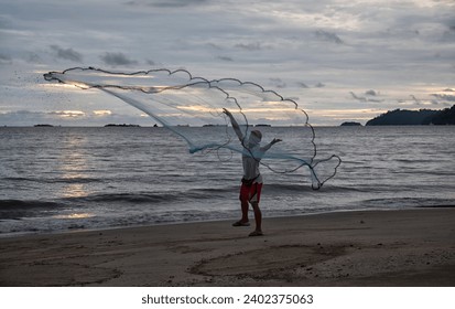 a man model throwing fishing net in the air.