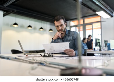 Man in modern office start-up working on laptop. - Shutterstock ID 486605749