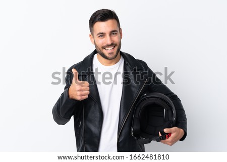 Man with a motorcycle helmet giving a thumbs up gesture