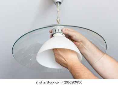 Man Mounts Lampshade Of Ceiling Lamp At Home