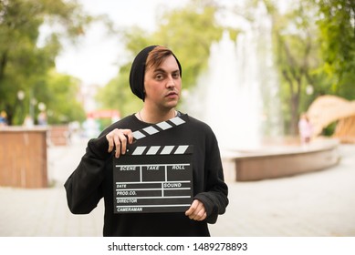 A man with movie clapper board outdoor