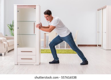 Man Moving Furniture At Home