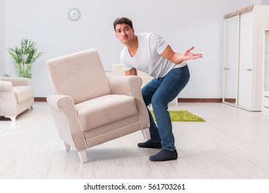 Man Moving Furniture At Home