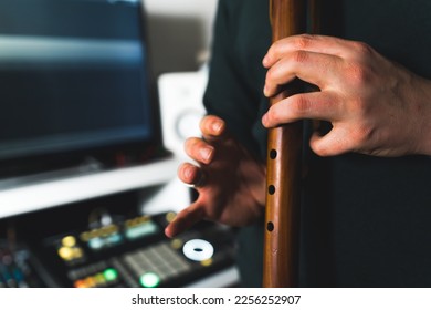 A man musician playing native American style flute. Close up hands at home music studio. High quality photo - Shutterstock ID 2256252907
