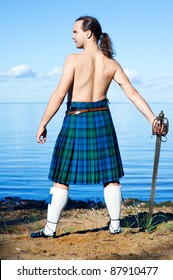 Man With Naked Torso In Kilt On The Sea Background