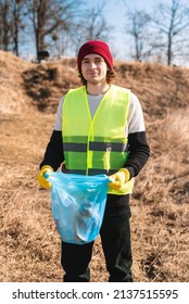 Man Nature Activist In Yellow Vest  Holds Open Blue Trash Bag